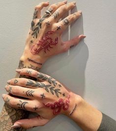 three hands with tattoos on them are holding each other's fingers and touching the wall