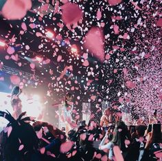 confetti falling from the ceiling at a concert with people in the foreground