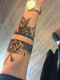 a woman's arm with a wrist watch on it and flowers around the wrist