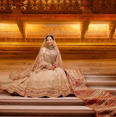 a woman in a wedding dress sitting on some steps