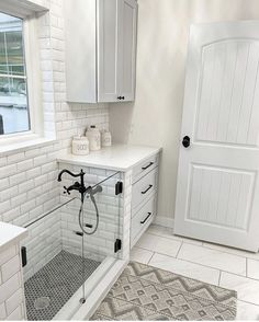 a bathroom with white cabinets and tile flooring