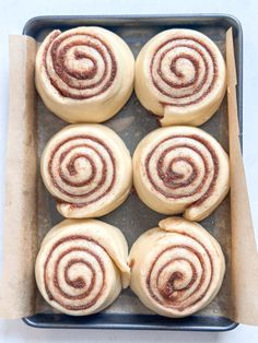 six cinnamon rolls on a baking sheet ready to be baked in the oven for dinner