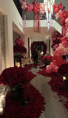 a hallway decorated with red and pink balloons, flowers and candles for valentine's day