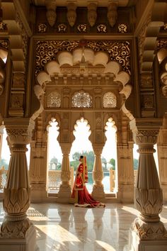 a woman in a red and gold outfit is standing under an ornate archway with columns