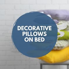 the words decorative pillows on bed are in front of a white brick wall and blue circle