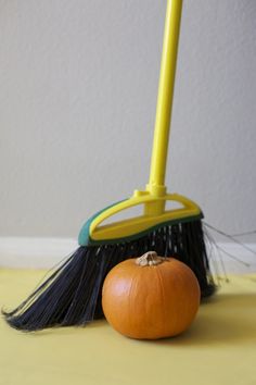 a broom and an orange sitting on the floor