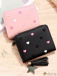 two wallets with hearts on them sitting next to each other and one has a tassel