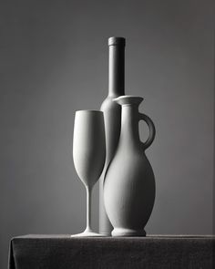 two white vases sitting next to each other on a table