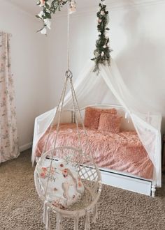 a white bed sitting next to a pink blanket on top of a floor