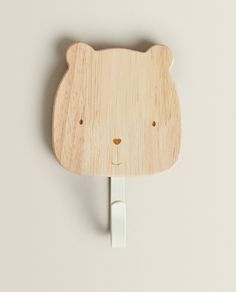 a wooden bear head plugged in to a white wall with the words zara home above it