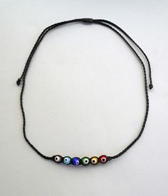 Evil eye beads necklace Evil Eye Rainbow Beaded Choker Necklace Yoga Gift Protection Present Choker necklace Dainty necklace Short necklace The evil eye is used to protect the person that wears it from the malevolent look of others who envy or dislike that person. The necklace is made with 1mm black waxed string,and has a 6mm rainbow color glass evil eye sphere beads. At the end it is adorned with black beads. Total length: 65cm / 25.5 inches It is adjustable to fit a lot of sizes. Custom orders Necklace Evil Eye, Evil Eye Beads, Chakra Necklace, Rainbow Beads, Eye Beads, Yoga Gifts, Blue Evil Eye, Minimal Jewelry, Beaded Choker Necklace