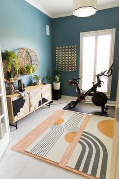 a room that has a bike and some plants on the floor in it with blue walls