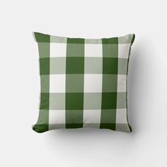 a green and white checkered pillow sitting on top of a wall