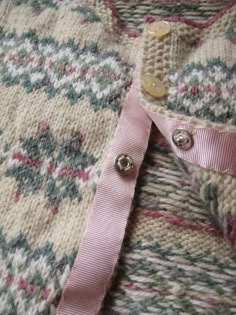 a close up of a sweater with buttons on it