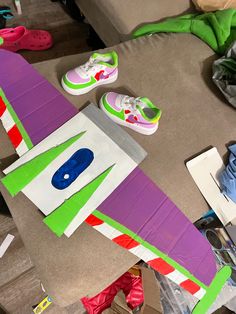 there is a purple and green kite on the floor next to some pairs of shoes