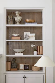 a white bookcase with books and pictures on it