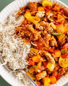 a white plate topped with rice and meat