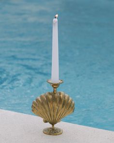 a candle that is sitting next to a pool