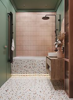 a bathroom with pink and green tiles on the walls, floor, and shower stall