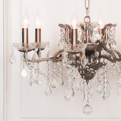 a chandelier hanging from the ceiling in a room with white walls and flooring