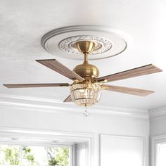 a ceiling fan in a white room with chandelier