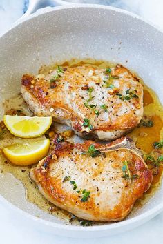 Pork chops cooked in a skillet with garlic and butter.