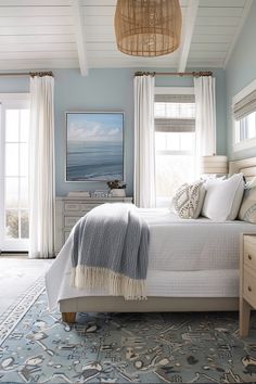 a bedroom with blue walls and white bedding has a painting on the wall above it