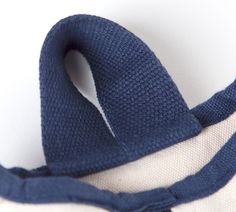 a blue and white sweater with a knot on the side that has been folded over