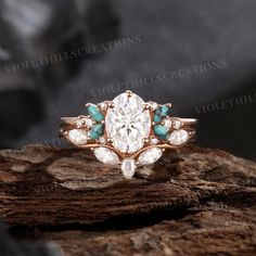 a diamond and turquoise stone ring sitting on top of a rock