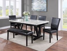 a dining room table with black chairs and a white marble top