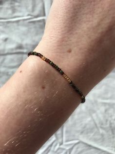 a close up of a person's arm with a beaded bracelet on it