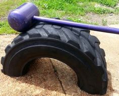 a purple baseball bat sitting on top of a tire