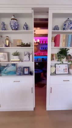 two white bookcases with blue and white vases on them