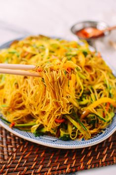 noodles with vegetables and chopsticks on a plate