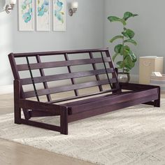 a wooden bench sitting on top of a rug in a living room next to a potted plant