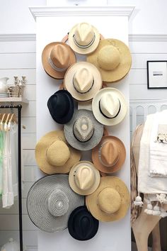 several hats are arranged on a wall in a room with white walls and flooring