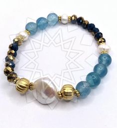 a bracelet with blue beads and gold accents on white background, showing the bead design