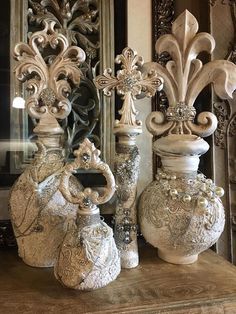 three ornate vases sitting on top of a wooden table in front of a mirror