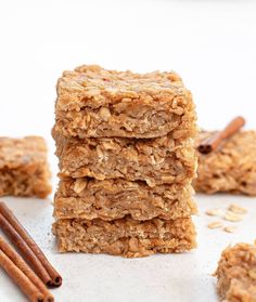 three granola bars stacked on top of each other with cinnamon sticks next to them