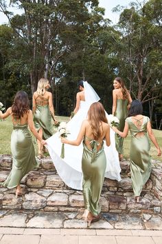 the bridesmaids are walking down the stone wall