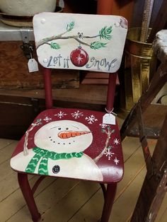 a wooden chair with a snowman painted on it