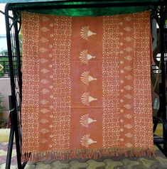 an orange and white cloth hanging from a metal stand