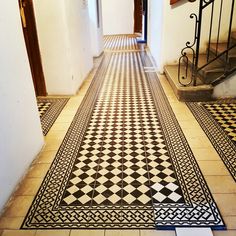 a hallway with black and white tiles on the floor