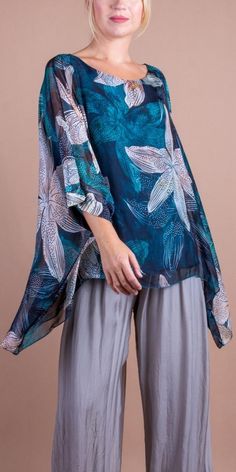 100% Silk Kaftan Style Blouse with a Floral Lily Print. Features 3/4 Length Sleeves and a Wavy Bottom. Exterior: 100% Silk Interior: 95% Viscose, 5% Elastic Fits Sizes XS- XL Made in Italy Half Sleeve Tops With Floral Print For Beach, Beach Blouse With Half Sleeves And Print, Printed Half Sleeve Beach Blouse, Beach Half Sleeve Printed Blouse, Flowy Floral Print Tunic Top, Floral Print Half Sleeve Blouse For Beach, Half Sleeve Blouse With Floral Print For Beach, Half Sleeve Floral Print Blouse For Beach, Summer Flowy Blouse With 3/4 Sleeves