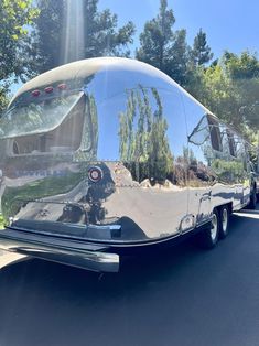 the rear end of an rv parked on the side of the road with trees in the background