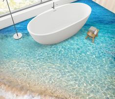 a bathtub sitting in the middle of a bathroom with blue water on the floor