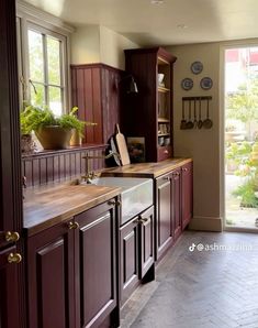 a kitchen with wooden cabinets and stainless steel sink in front of an open door that leads to the outside patio