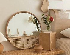 a bedroom with a bed, mirror and vase on the nightstand next to each other