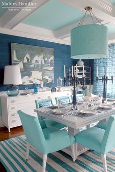 a dining room with blue walls and white furniture