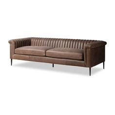 a brown leather couch sitting on top of a white floor